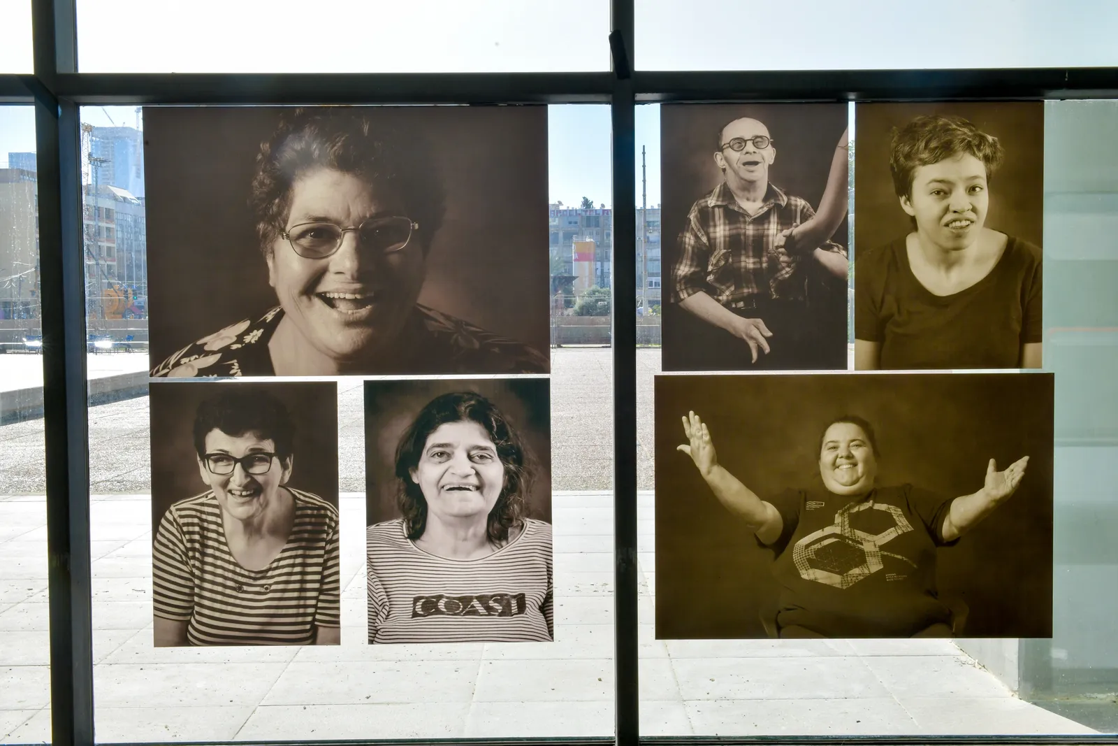 מבט מקרוב על קיר התצוגה — רשת פורטרטים בשחור-לבן מתוך התערוכה בעיריית תל אביב-יפו