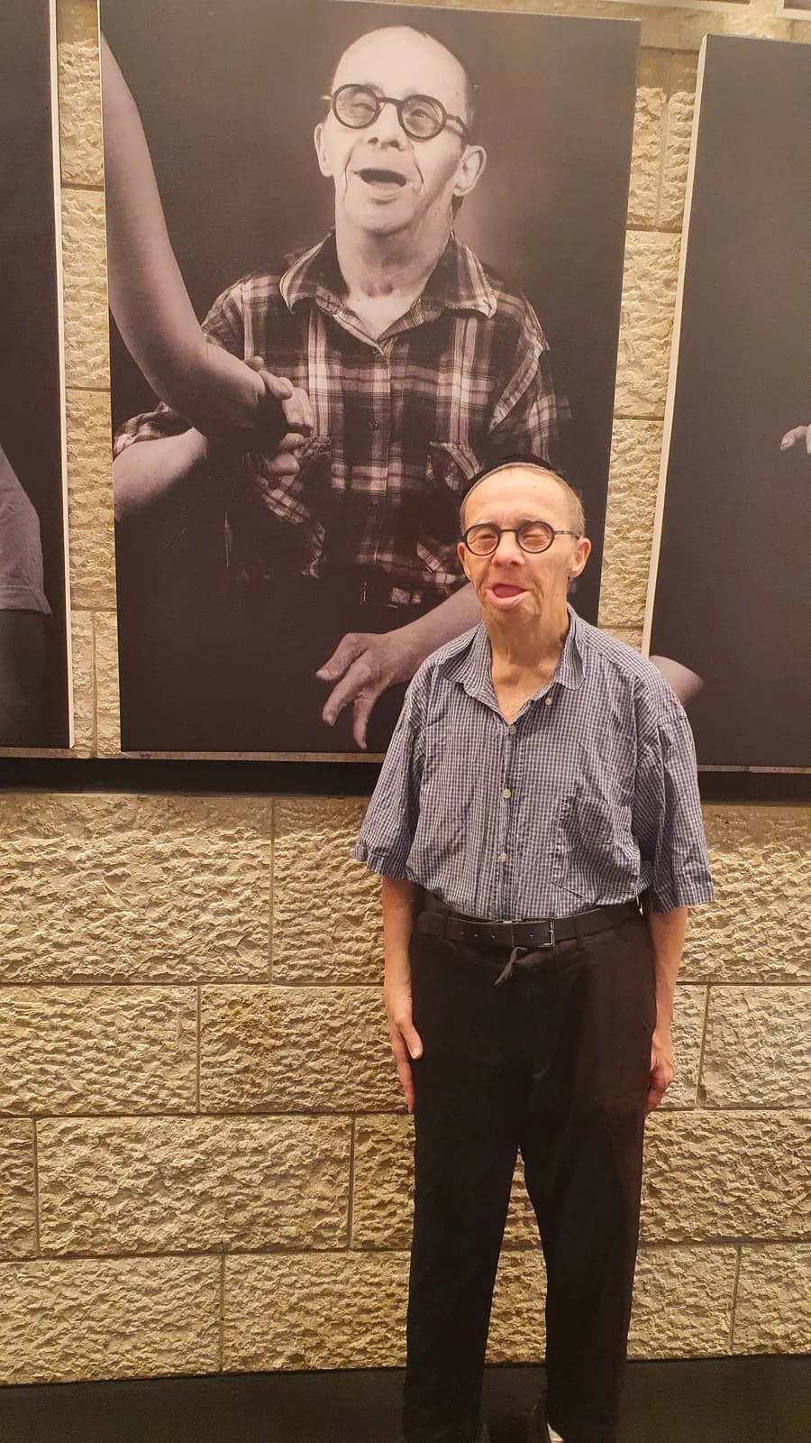 A visitor in front of a large black-and-white portrait at Sharon Gabay's “At Eye Level” exhibition