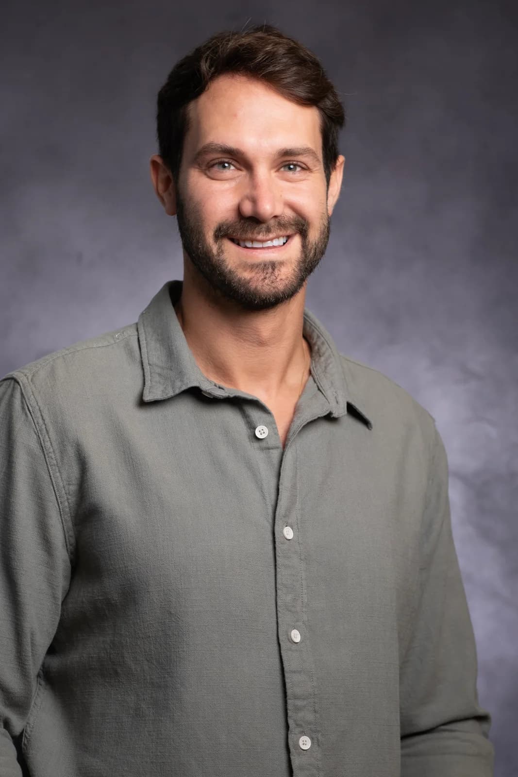 A young entrepreneur smiling in a light button-down shirt — headshots for high-tech by Sharon Gabay