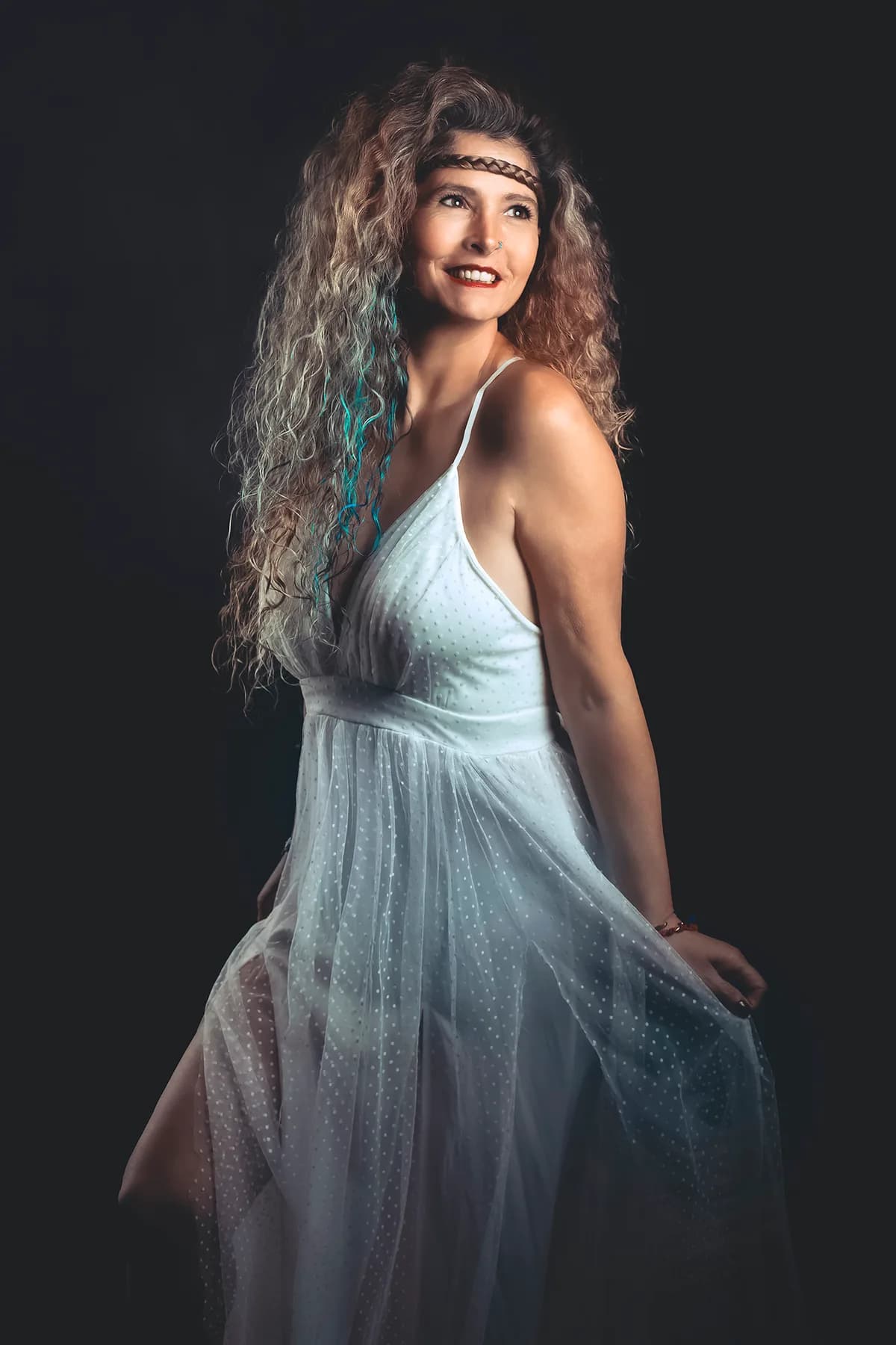 Personal portrait of a woman in a flowing white dress with curly hair — fine-art studio photography | Photo: Sharon Gabay