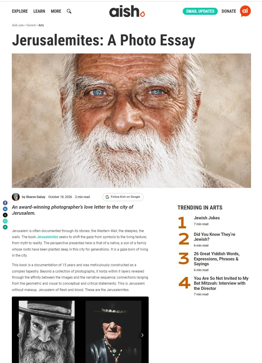 The opening of the photo essay "Jerusalemites: A Photo Essay" on Aish.com: the headline, the lead photograph, a close portrait of a white-bearded man with blue eyes, the byline "by Sharon Gabay" with the date October 18, 2026, the standfirst "An award-winning photographer's love letter to the city of Jerusalem", the opening paragraphs and the start of the gallery of spreads from the book