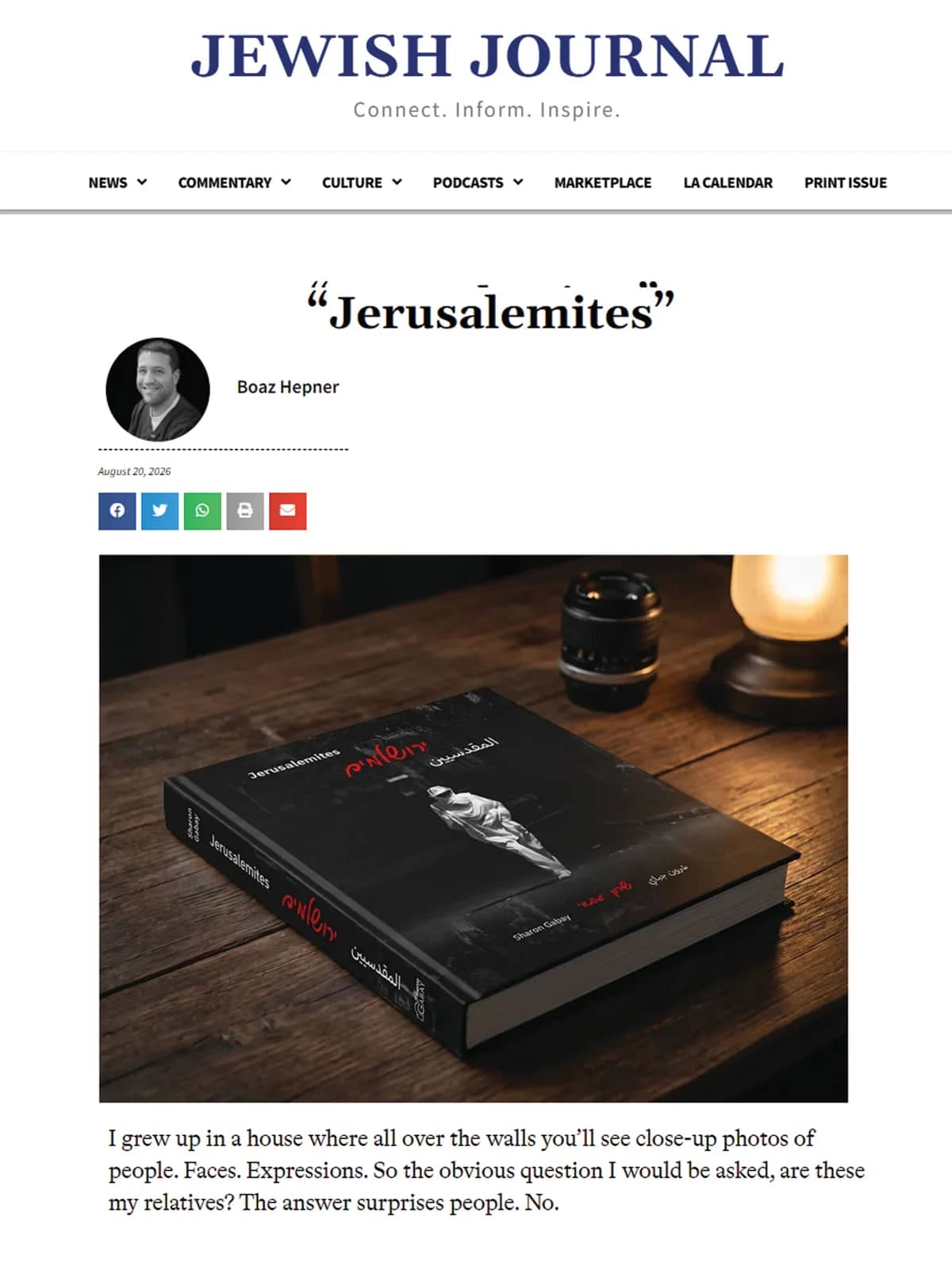 The opening of the feature "Jerusalemites" in the Jewish Journal by Boaz Hepner, carrying the photography book "Jerusalemites" lying on a wooden table beside a camera lens and a lit lamp