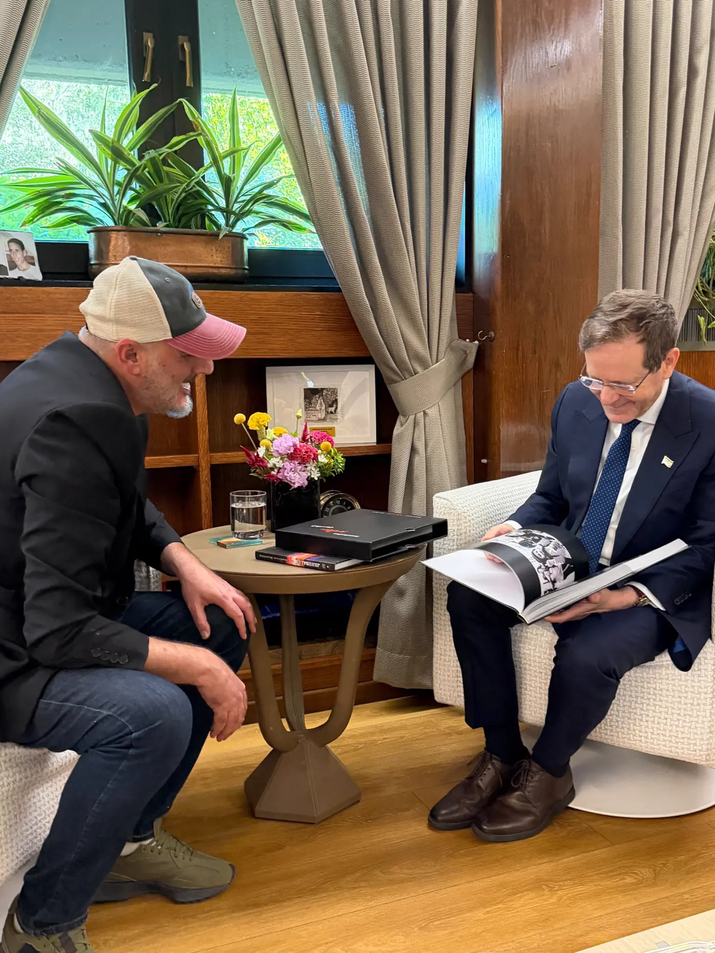 נשיא המדינה יצחק הרצוג מעיין בספר הצילום ״ירושלמים״, שרון גבאי לצדו