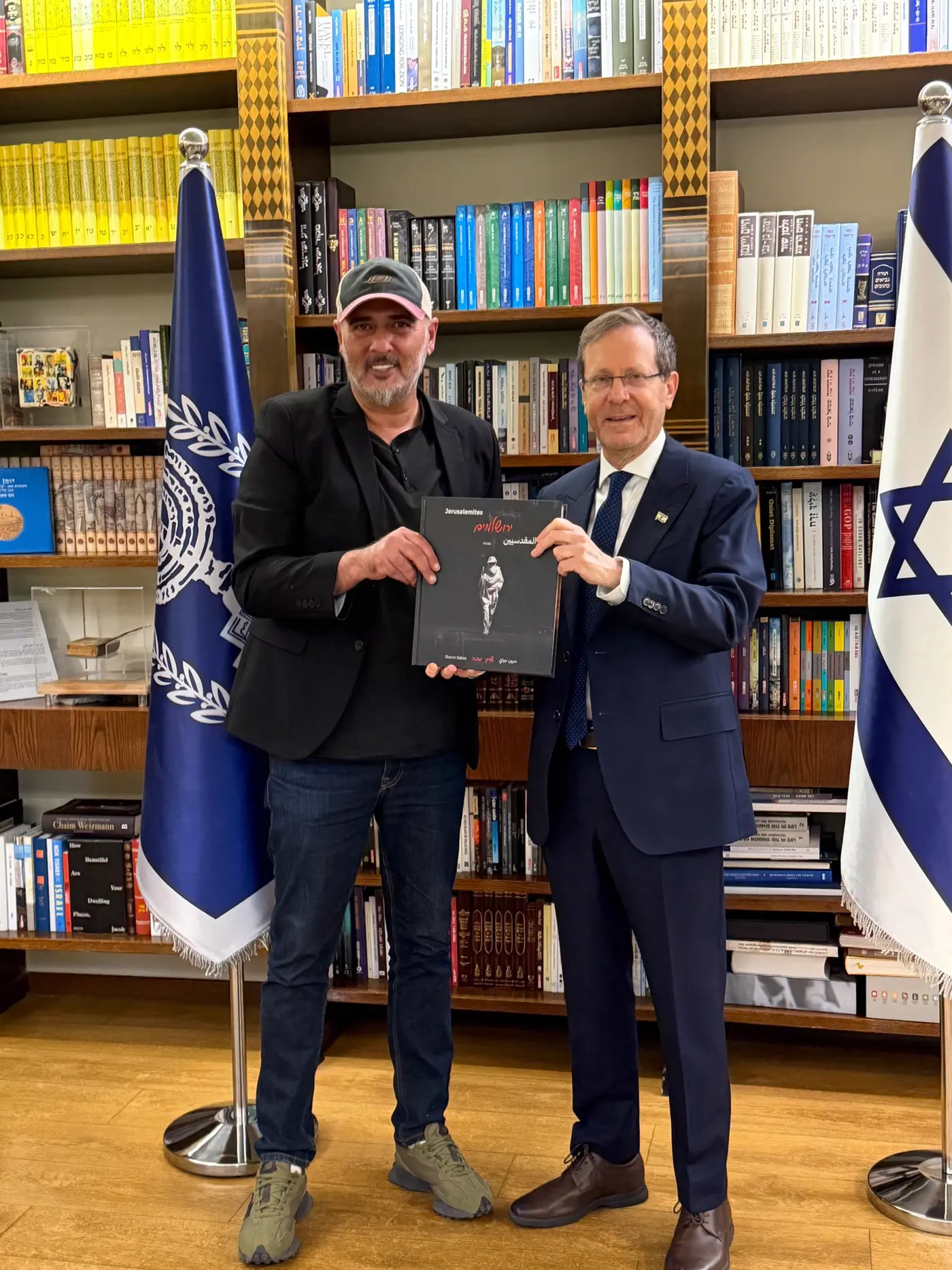 Sharon Gabay and Israel's President Isaac Herzog holding the photography book “Jerusalemites” at the President's Residence