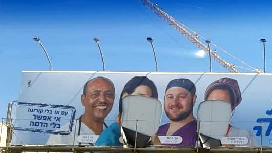 A billboard on which the women's faces have been defaced while the men's remain intact — documentation of the exclusion of women