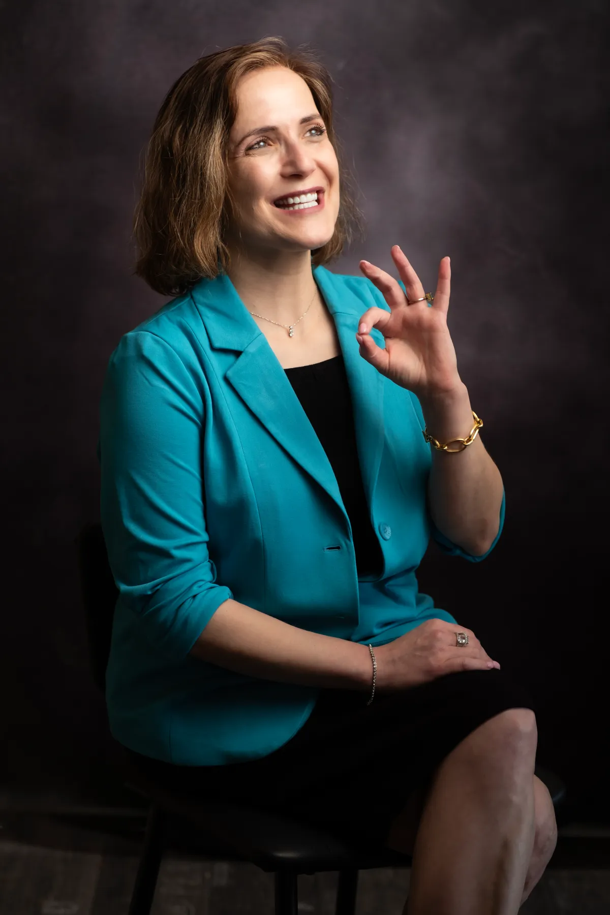 Headshot of a woman in a teal blazer laughing with an authentic expression — a documentary expression, Docu-Studio approach