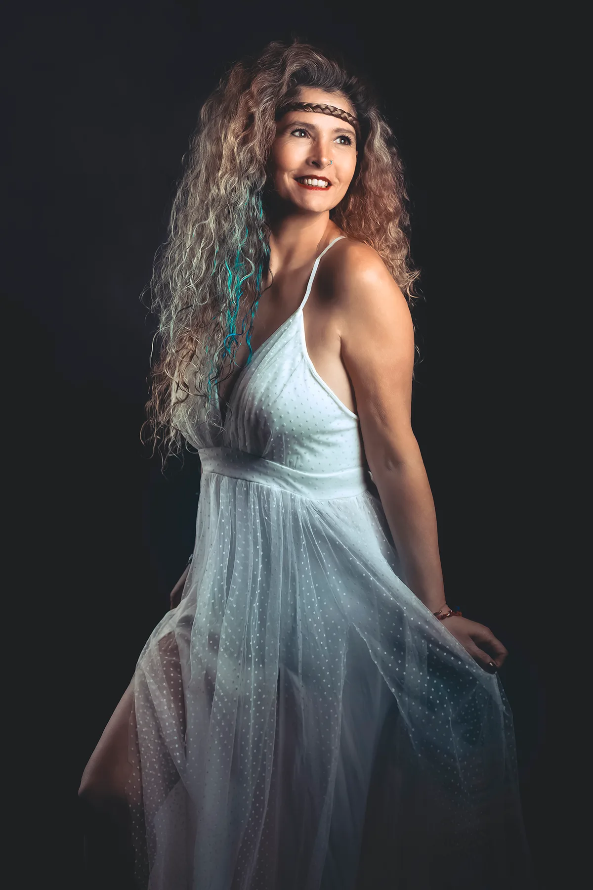 Personal portrait of a woman in a flowing white dress with curly hair — fine-art studio photography | Photo: Sharon Gabay