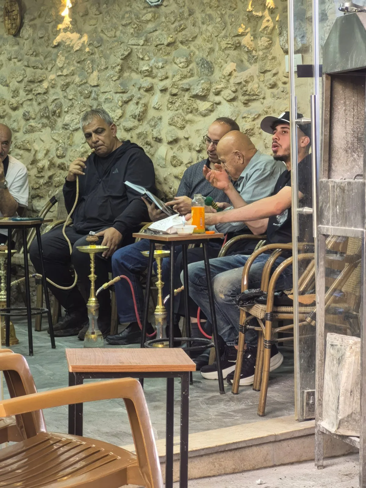Guests at Abu Yasser's café looking through the book.