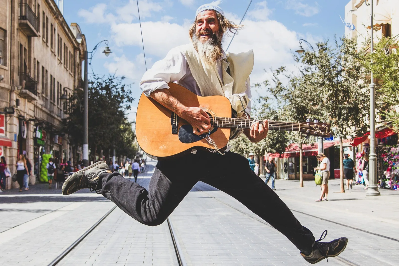 The photograph opening the photo essay in The Jewish Independent, a musician leaping in mid-air with a guitar on Jaffa Road in Jerusalem, from the book "Jerusalemites"