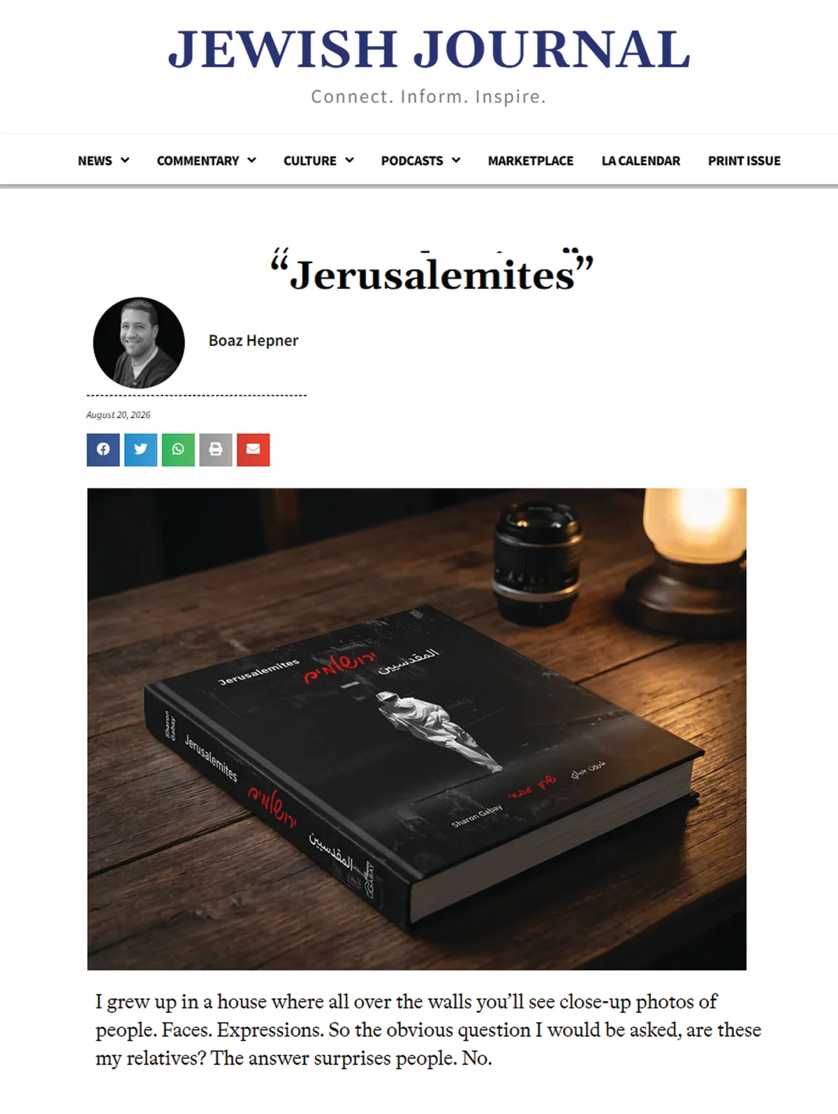 The opening of the feature "Jerusalemites" in the Jewish Journal by Boaz Hepner, carrying the photography book "Jerusalemites" lying on a wooden table beside a camera lens and a lit lamp