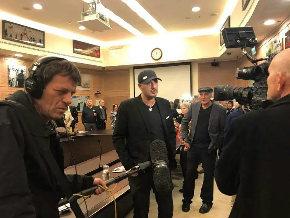 Sharon Gabay interviewed on television at the opening of the Knesset exhibition, 2016